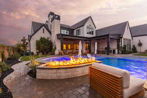 Rear view of house featuring an outdoor fire pit, a patio area, an outdoor pool, a chimney, and an outdoor kitchen with living area