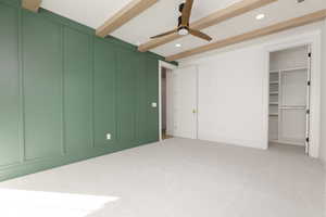 Unfurnished bedroom with carpet floors, recessed lighting, a spacious closet, beamed ceiling, and ceiling fan