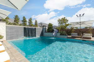 View of pool with a fenced backyard and patio surround