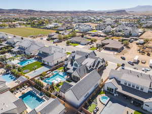 Aerial view of residential area featuring a pool and a mountainous background