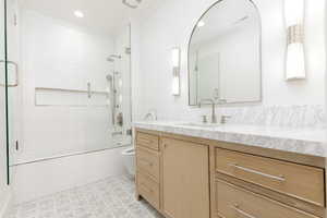 Full bath featuring vanity, shower / bath combination with glass door, and recessed lighting