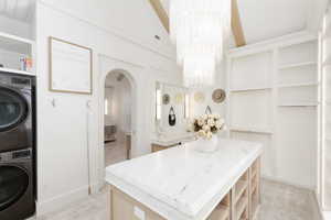 Bathroom featuring suspended lighting, stacked washer and dryer, and vanity