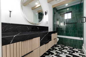 Bathroom with vanity, radiator, tiled shower / bath combo, and dark flooring