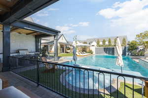 View of pool featuring patio surround, a fenced backyard, and area for grilling