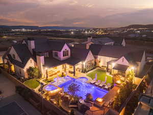 Aerial view at dusk of view of pool area and a mountain view