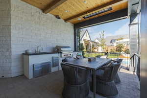 View of patio / terrace featuring an outdoor kitchen / dining area and a sink