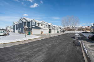 View of asphalt street with a residential view, sidewalks, and curbs