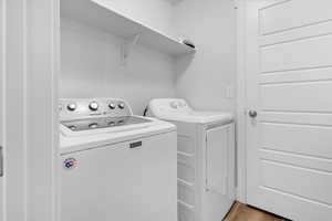 Laundry room featuring washer and dryer and light wood-style flooring