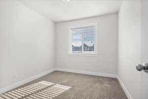 Empty room with baseboards and light colored carpet