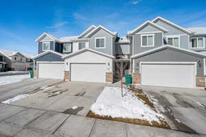 Craftsman-style house with board and batten siding, driveway, a residential view, and a garage