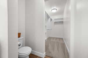 Bathroom featuring a walk in closet and light wood-style floors