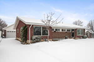 Ranch-style house with a garage and brick siding