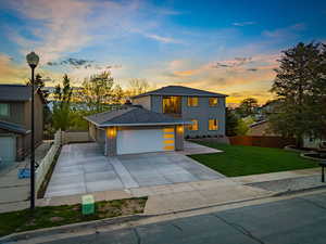 Modern home with a garage, concrete driveway, and brick siding