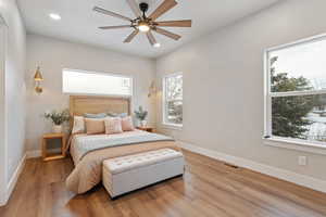 Primary bedroom with wood finished floors, a ceiling fan, and recessed lighting