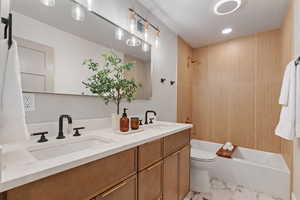 Full bathroom featuring double vanity, shower / bathtub combination, and recessed lighting