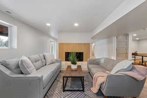 Living room featuring a fireplace with raised hearth and recessed lighting