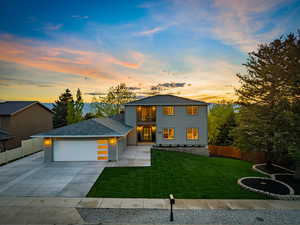 View of front facade with a balcony, a garage, concrete driveway, and a shingled roof