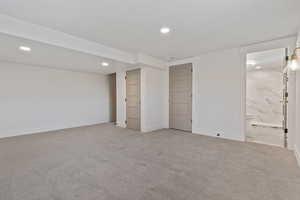 Basement with light colored carpet and recessed lighting