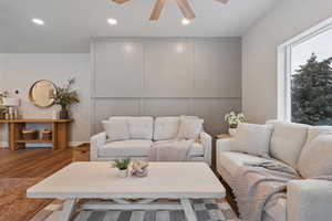 Tastefully modern living area featuring ceiling fan, recessed lighting, and large wndow for natural lighting