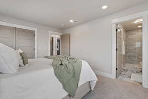 Carpeted bedroom featuring a closet, recessed lighting, and ensuite bathroom