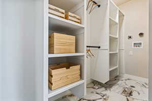 Walk in closet with light marble finish floors