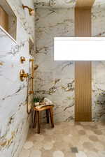Full bath with a marble finish shower