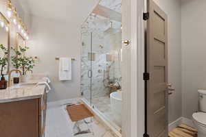 Primary ensuite bathroom with a tile finished shower, vanity, and light tiled floors