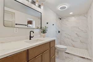Full bathroom featuring vanity, a tile finish shower, light tile finish floors, and recessed lighting