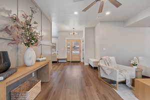 Foyer entrance featuring wood finished floors, a ceiling fan, and a chandelier