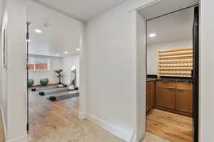 Hallway featuring entrance of gym and wine room/cold storage