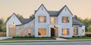 View of front of property with an attached garage, stone siding, driveway, and roof with shingles