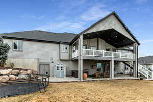 Rear view of property with a patio area, a shingled roof, a wooden deck, and a hot tub