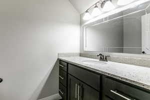 Bathroom with vanity, backsplash, and a textured ceiling