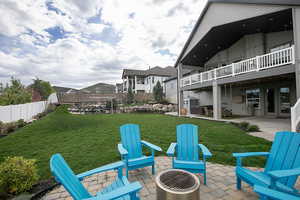 Fenced yard featuring a patio, an outdoor fire pit, and a balcony