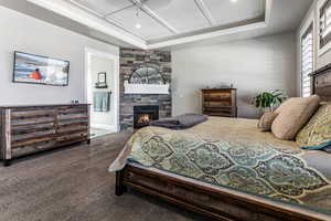 Bedroom with a fireplace, dark colored carpet, and ensuite bathroom
