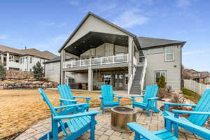 Rear view of property featuring a patio area, a fire pit, a balcony, and a residential view