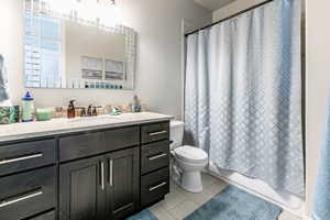 Bathroom featuring vanity and shower / bathtub combination with curtain