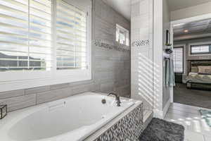 Full bathroom with ensuite bath, a tile shower, a bath, tile patterned flooring, and plenty of natural light
