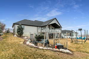 Rear view of property with a patio area, a shingled roof, and a balcony