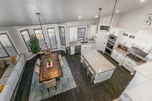Living area with vaulted ceiling, wood tiled floors, and recessed lighting