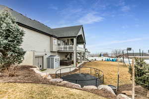 Rear view of house featuring a patio area and a shingled roof