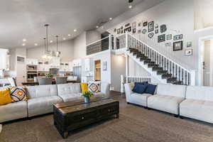 Living area featuring suspended lighting and lofted ceiling