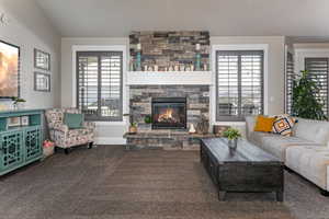 Living room featuring carpet, a fireplace, and plenty of natural light