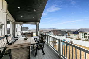 Wooden deck with outdoor dining area, a mountain view, and a residential view