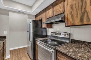 Kitchen with electric range, light wood-type flooring, and wood finish cabinets
