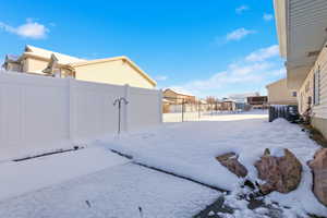 Yard layered in snow with a fenced backyard and a residential view