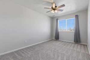 Empty room featuring light carpet and ceiling fan