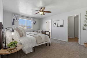 Carpeted bedroom with a textured ceiling and ceiling fan