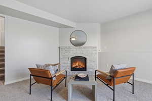 Living area featuring light colored carpet and a fireplace