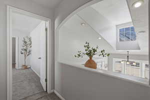 Corridor with healthy amount of natural light, carpet floors, and recessed lighting